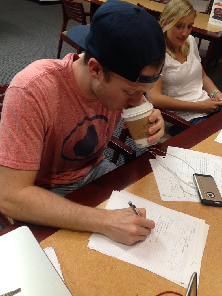 Junior volleyball player Josh Stewart takes another sip of coffee to help get him through homework as sophomore Madi Frohling looks on. (Photo by Joie Eckhard)